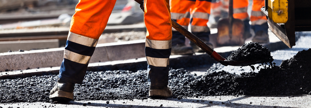 Road construction, worker with shovel